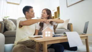 Asian couple in their living room giving a hand pump to each other.